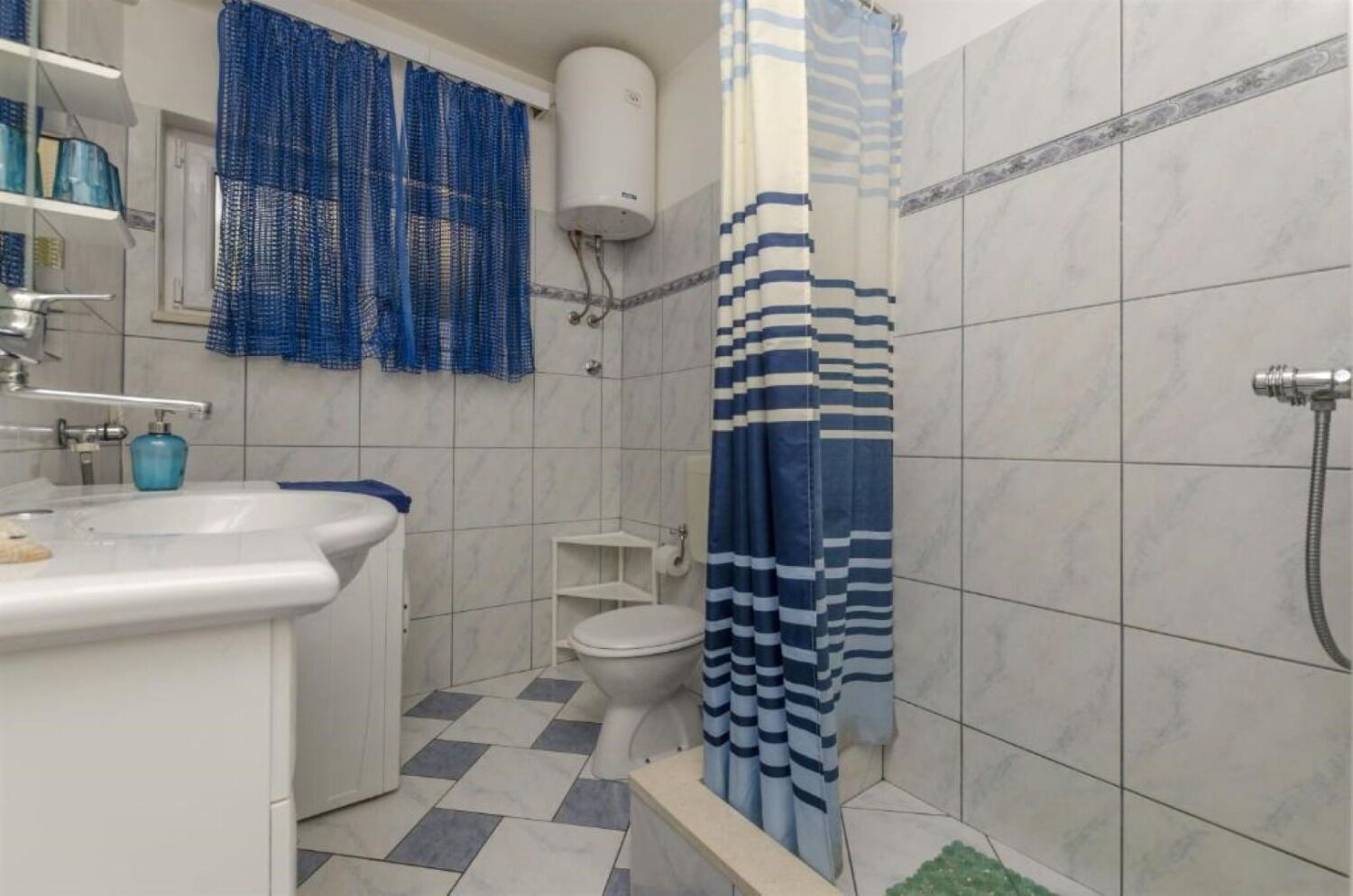 Un bagno con lavandino bianco, servizi igienici e zona doccia.