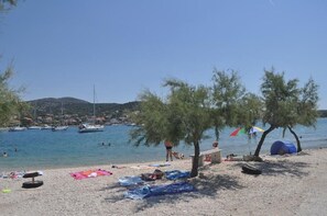 A beach with boats, tents, and people. - Apartments Antonija (Marina)