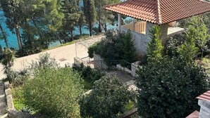 A coastal residential area with a view of the sea, a small gazebo, and a staircase leading to a building. - Apartment Dino (Supetar)