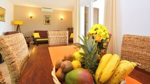A dining area with a wooden table, wicker chairs, and a fruit basket. - House Sreca (Okrug)