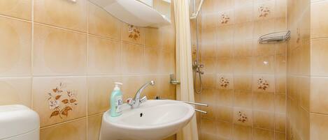 A bathroom with a sink, shower, and toilet.