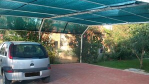 Zona d'aparcament coberta amb un cotxe sota un sostre blau.