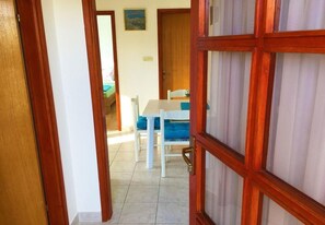 A hallway leading to a dining area with a table and chairs. - Apartment Mir (Tisno)