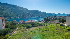 Une ville côtière avec des bâtiments qui bordent le front de mer, un lac d’un bleu limpide et des collines en arrière-plan.
