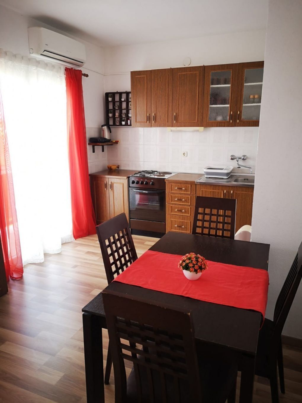 A compact kitchen with wooden cabinets, a gas stove, and a sink.