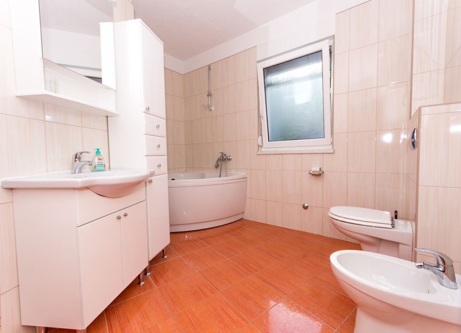 A modern bathroom with a sink, toilet, and bathtub.