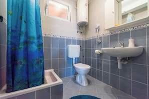 Un baño con inodoro, lavabo y cortina de ducha.