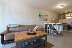 Una sala de estar moderna con un sofá, una mesa de centro de madera y un comedor con sillas y una mesa.
