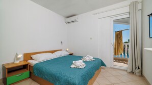Une chambre à coucher avec un lit, une table de chevet et une vue sur l’extérieur.