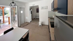 A modern kitchen with a dining area, a built-in oven, and a view to the outside. - Apartment Matija (Tisno)