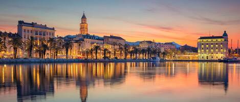 A waterfront cityscape with a prominent tower and buildings along the shore.