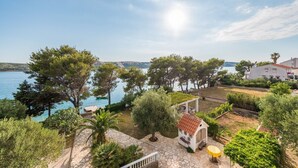 A coastal property with a stone patio, a small outdoor kitchen, and a view of the sea. - Apartments Jadra (Novalja)