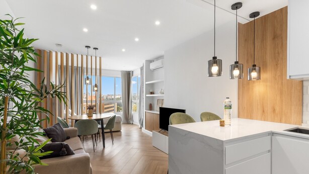 A modern kitchen with a central island, wooden accents, and pendant lighting. - Apartment 'Sky Costa Del Sol' with Shared Pool, Wi-Fi and Air Conditioning (Torremolinos)