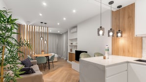 A modern kitchen with a marble countertop, wooden cabinets, and pendant lighting. - Apartment 'Sky Costa Del Sol' with Shared Pool, Wi-Fi and Air Conditioning (Torremolinos)