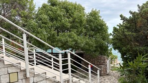 A stone staircase with white railings leading to a building with a stone wall. - Apartments Neno (Karlobag)