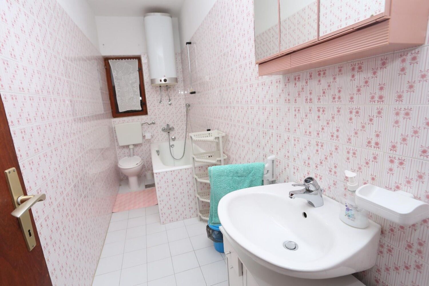 A bathroom with a toilet, sink, and shower.
