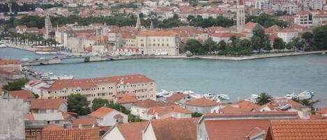 A coastal town with red-roofed buildings, a prominent church, and a marina with boats.