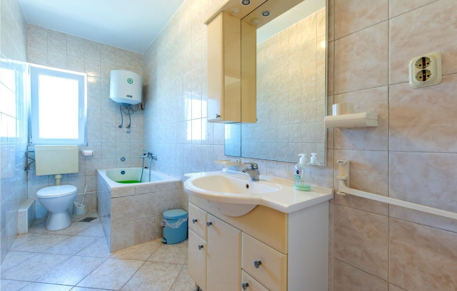 Ein Badezimmer mit Toilette, Waschbecken, Badewanne und Spiegel.