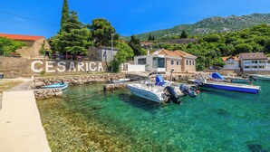 Uma marina com barcos atracados, água cristalina e edifícios ao fundo.
