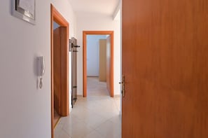 Ein Korridor mit einer Holztür, einem Telefon und einem gerahmten Zertifikat an der Wand.
