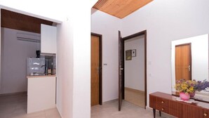 A modern kitchen with a built-in dishwasher and a small countertop. There is a wooden cabinet and a wooden ceiling. - Apartments Marko (Pag)
