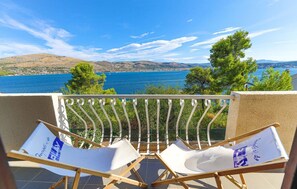 A balcony with two white lounge chairs facing a scenic view of a lake and mountains. - House Jelka (Okrug)