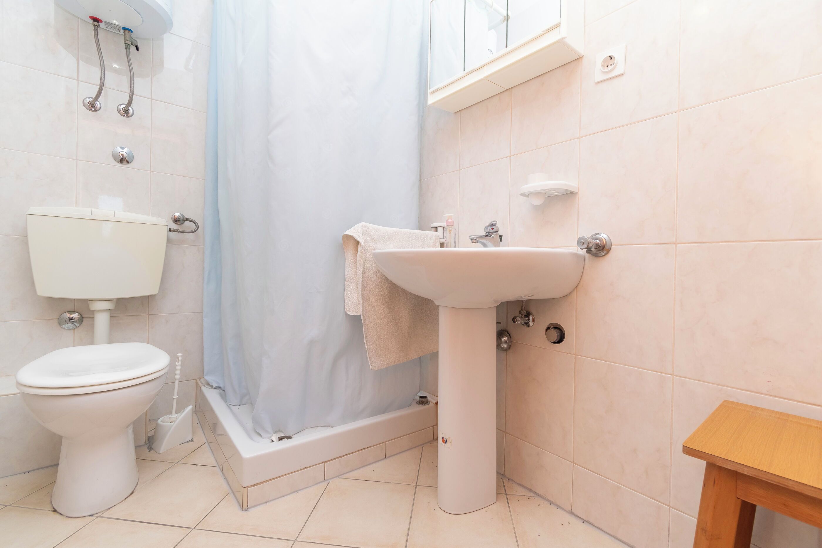 Un baño con inodoro, lavamanos y ducha.