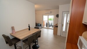 A modern kitchen with a wooden table, four chairs, and a microwave. - Apartment Danka (Novalja)