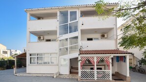 A multi-story building with a central staircase, balconies, and a small porch area. - Apartment Danka (Novalja)