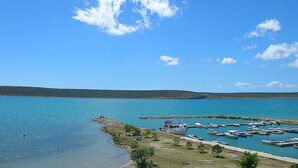 A marina with boats docked, a clear sky, and a distant shoreline. - Apartments Blue Skies (Razanac)