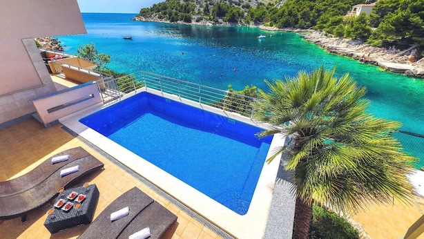 A swimming pool with a view of a turquoise sea and a mountainous landscape. - House Silva (Rogoznica)