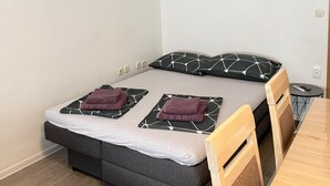 A bedroom with a bed, a wall clock, a picture, and a small table. - Apartment Kety (Novalja)