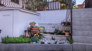 Un pequeño patio con diversos maceteros y un tocón de árbol como elemento central.