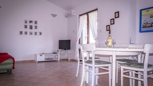 Una sala de estar con comedor, televisión y una mesa puesta para dos.