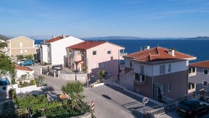Zona residencial costera con edificios, una calle pavimentada y vistas al mar.