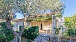 Une maison en pierre avec un toit en tuiles, une porte d’entrée et un escalier menant à l’intérieur.