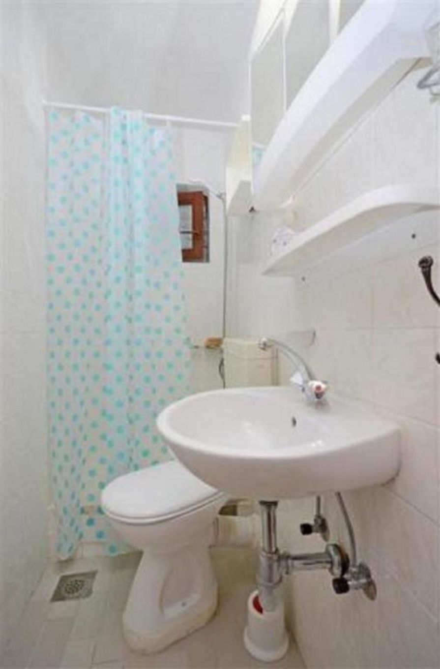 Un baño con inodoro, lavamanos y cortina de ducha.
