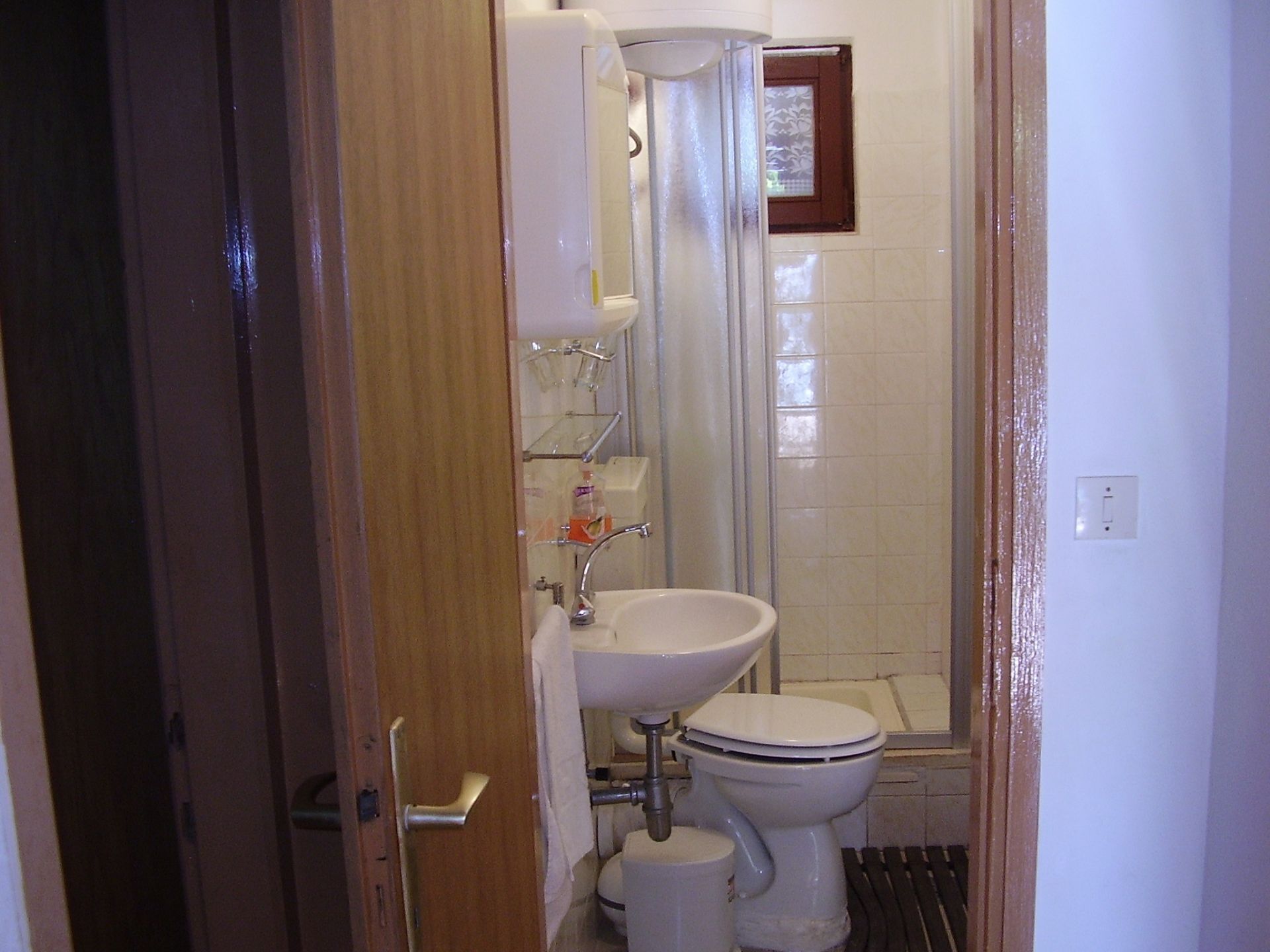A bathroom with a toilet, sink, and shower.