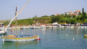 A marina with several boats docked, a clear sky, and buildings in the background. - Apartments Adriatic (Razanac)