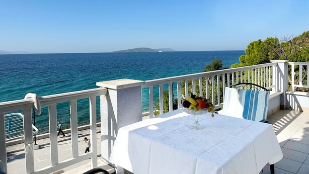 A seaside terrace with a table set for dining, overlooking the sea. - Apartments Tomo (Gradac)