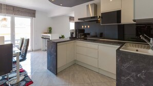 Una cocina moderna con una isla grande, electrodomésticos integrados y un comedor con vistas.