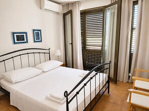A neatly made bed with white linens, a bedside lamp, and two framed pictures on the wall. - Apartment Zeljka (Rogoznica)