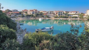 Un pittoresco villaggio costiero con case, un porto turistico e imbarcazioni.