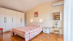 A bedroom with a bed, bedside table, and a mirror. - Apartment Ivan (Sali)