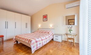 A bedroom with a bed, bedside table, and a mirror. - Apartment Ivan (Sali)