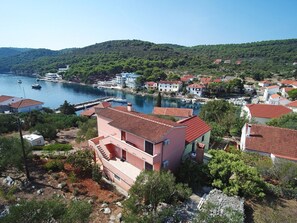 A coastal town with houses, a marina, and a hilly backdrop. - Apartment Ivan (Sali)