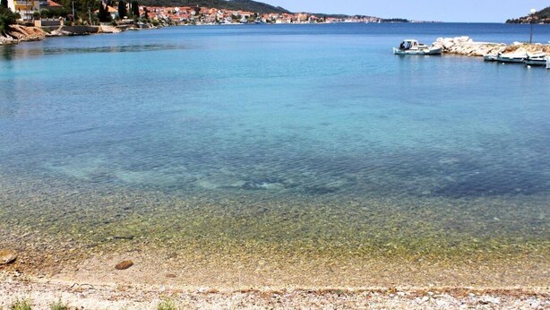 A coastal town with clear blue waters, rocky shoreline, and buildings along the coast. - Apartments Tonci (Kali)