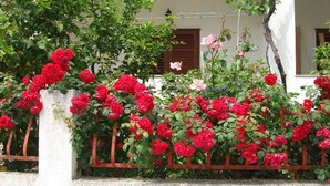 A building with a white exterior and a red metal fence. - Apartments Stuk (Orebic)