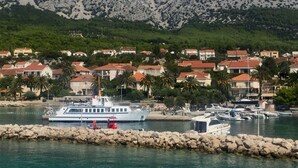 A coastal town with a marina, boats, and houses with red roofs. - Apartments Stuk (Orebic)