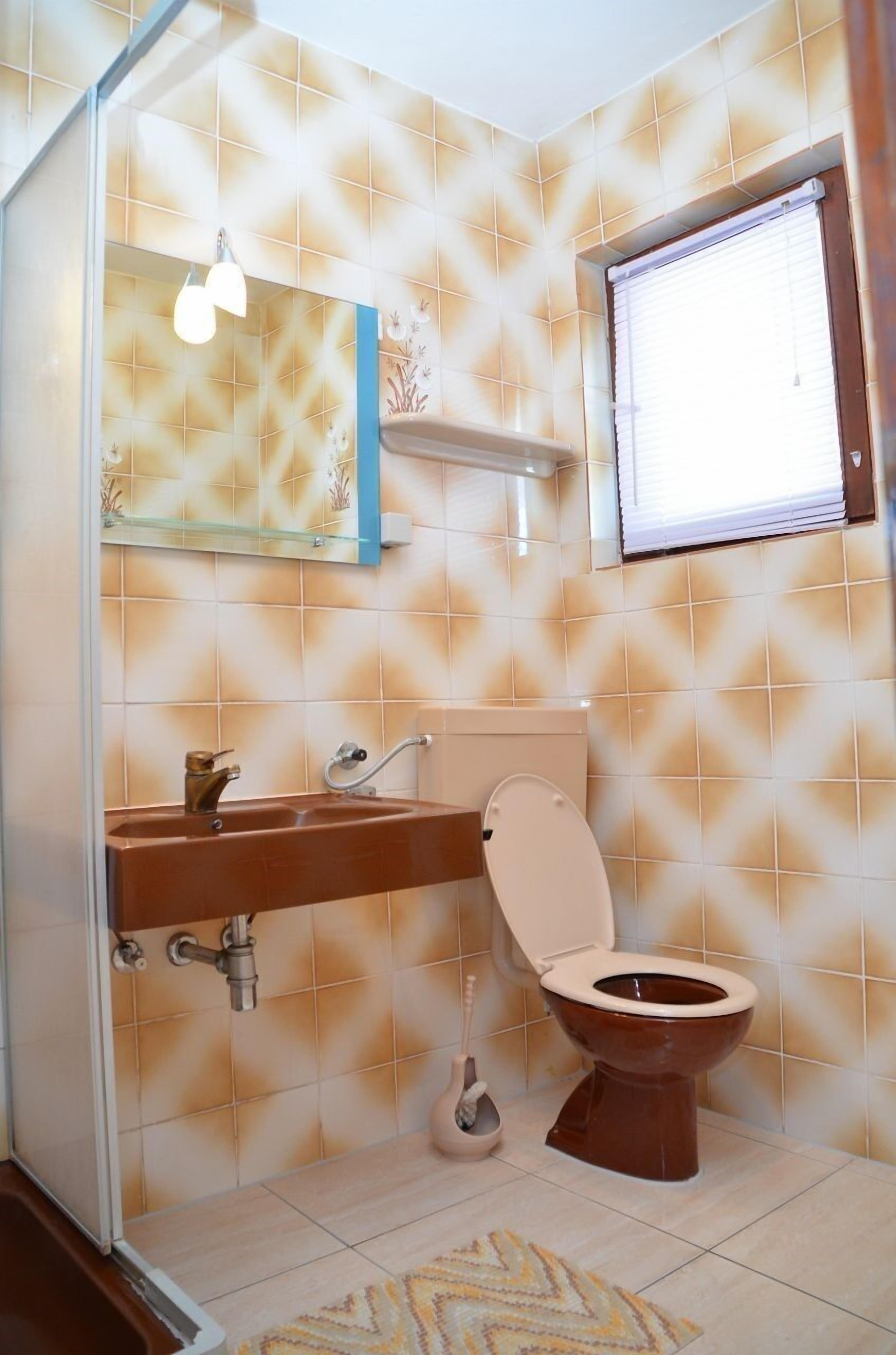 Une salle de bain avec des toilettes, un lavabo et un miroir.